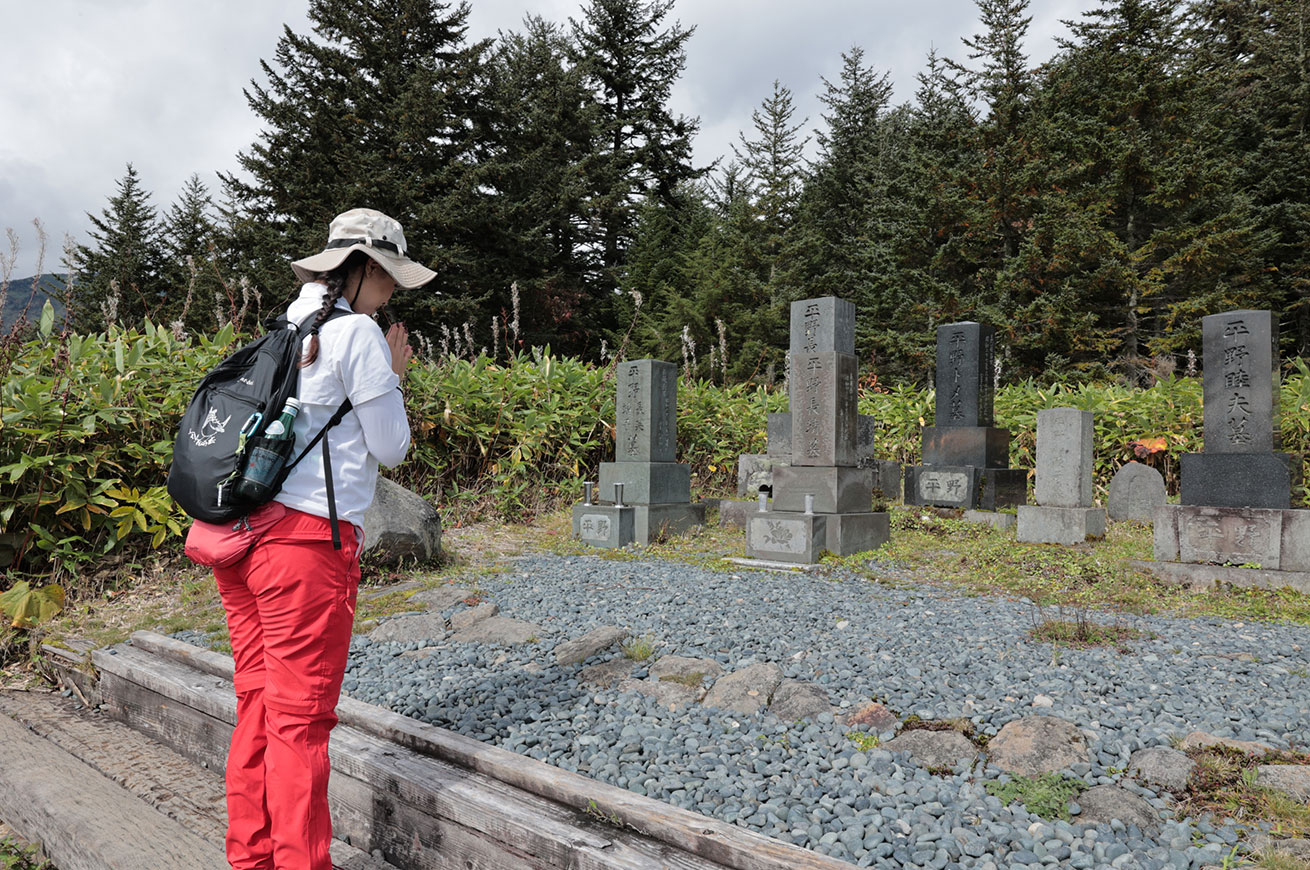Praying at the memorial marker on the hill of the marshland